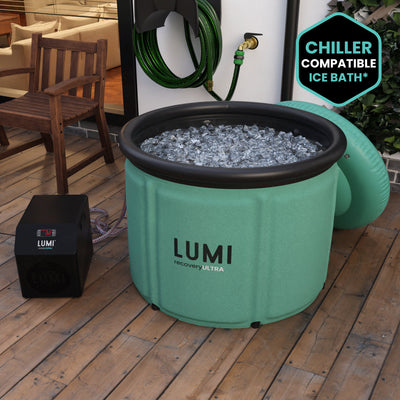 The Mint green LUMI Max Ultra ice bath, filled with ice in a garden setting.