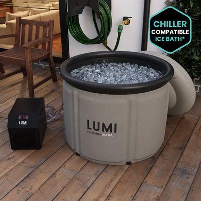 The Stone grey LUMI Max Ultra ice bath, filled with ice in a garden setting.