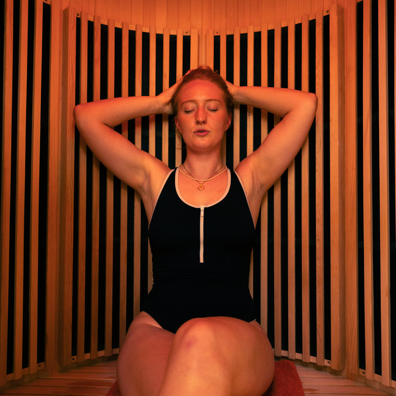 A woman relaxing in the LUMI Sauna PRO infrared home sauna