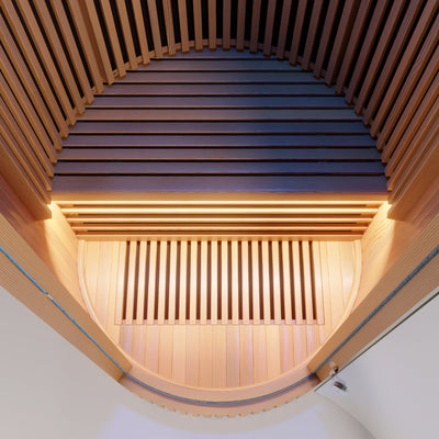 LUMI Infrared Sauna PRO interior view showcasing premium Hemlock wood slats in curved architectural design, with warm ambient lighting highlighting the elegant barrel-vault ceiling and minimalist Scandinavian craftsmanship.
