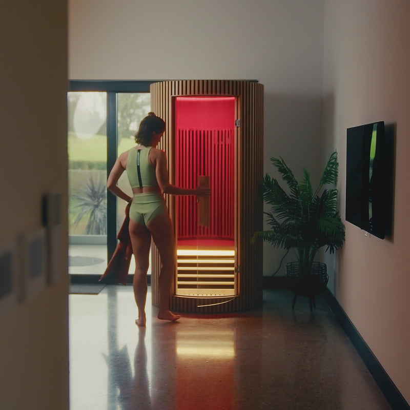Video of a woman stepping into the LUMI Sauna PRO infrared wooden sauna.